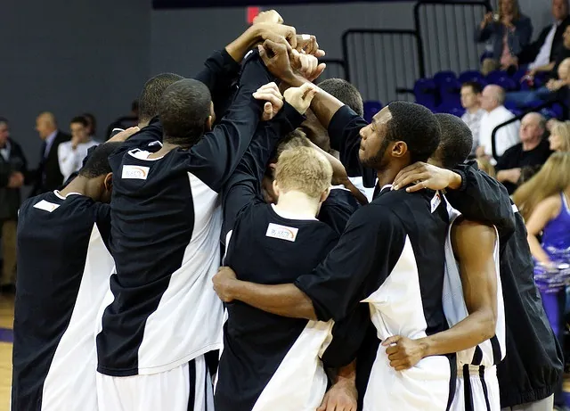 The Men's Basketball team of High Point University unites around their lone senior before the beginning of the final home game of the season.